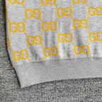 Close-up of sweater hem with ribbed trim and yellow GG logo pattern