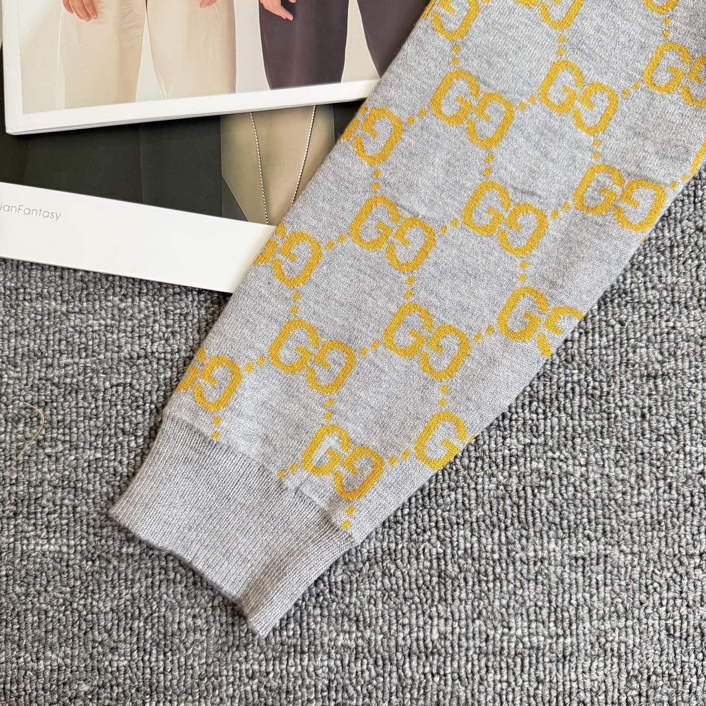 Heather gray sweater with yellow GG logo knit pattern and ribbed sleeve cuff