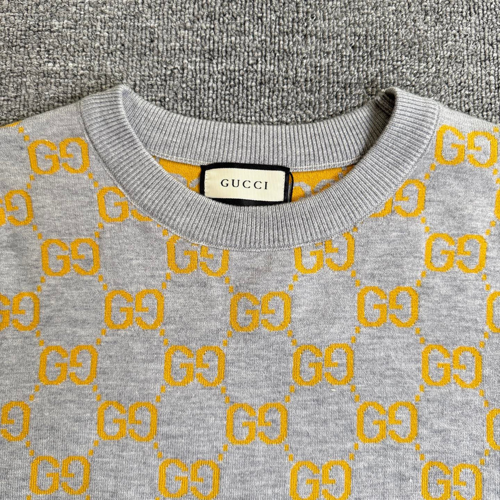 Heather gray sweater neckline with yellow GG logo pattern and ribbed collar