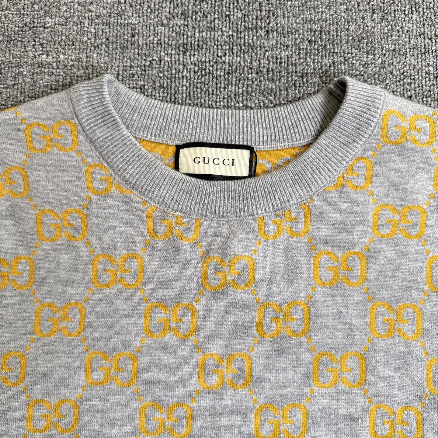 Heather gray sweater neckline with yellow GG logo pattern and ribbed collar