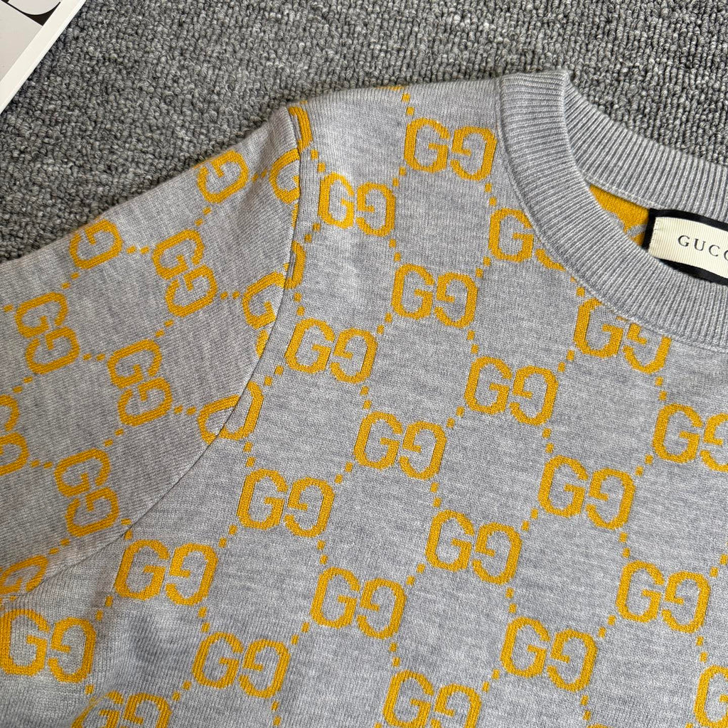 Heather gray long-sleeve sweater with yellow GG logo pattern and ribbed cuffs