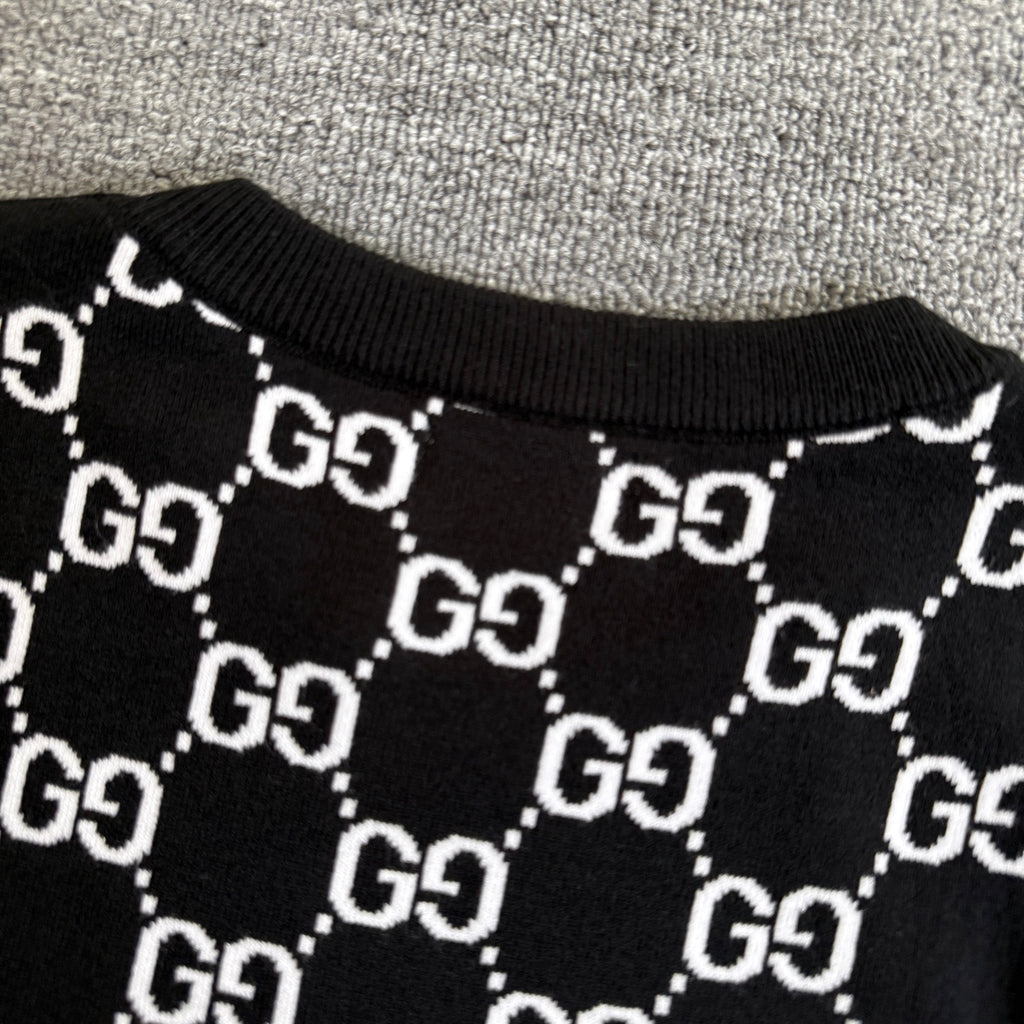Black knit sweater neckline with repeating white GG logo lattice pattern