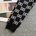 Black knit sweater sleeve with ribbed cuff and repeating GG logo lattice pattern