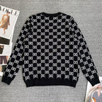 Black knit sweater with repeating white GG logo lattice pattern and ribbed cuffs