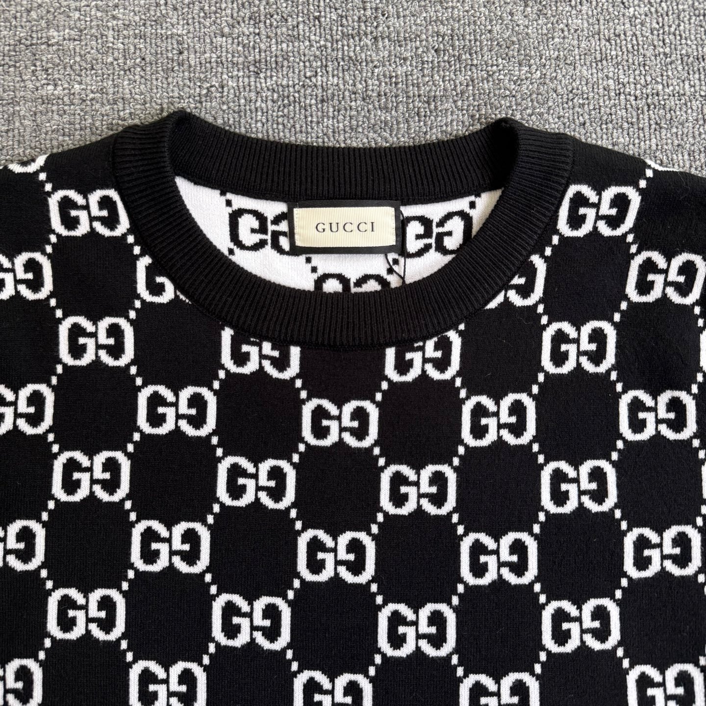 Black knit sweater crew neck with ribbed collar and repeating GG logo pattern