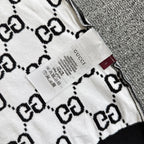 Gucci label and care tag on white-and-black GG logo knit top