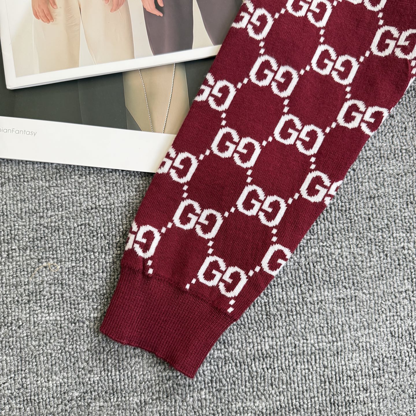 Burgundy Gucci sweater sleeve with white GG diamond pattern knit cuff