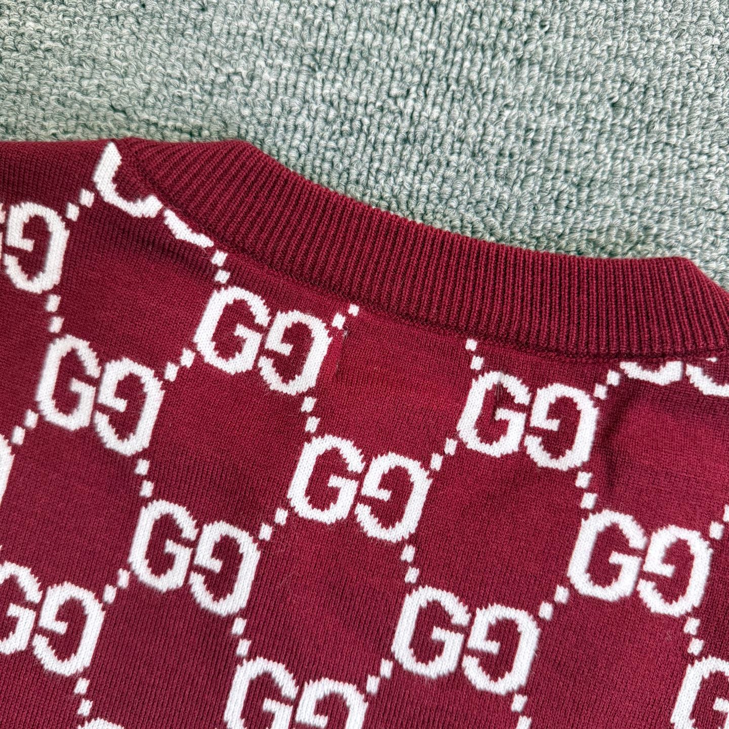 Burgundy Gucci sweater collar and shoulder area with white GG diamond pattern