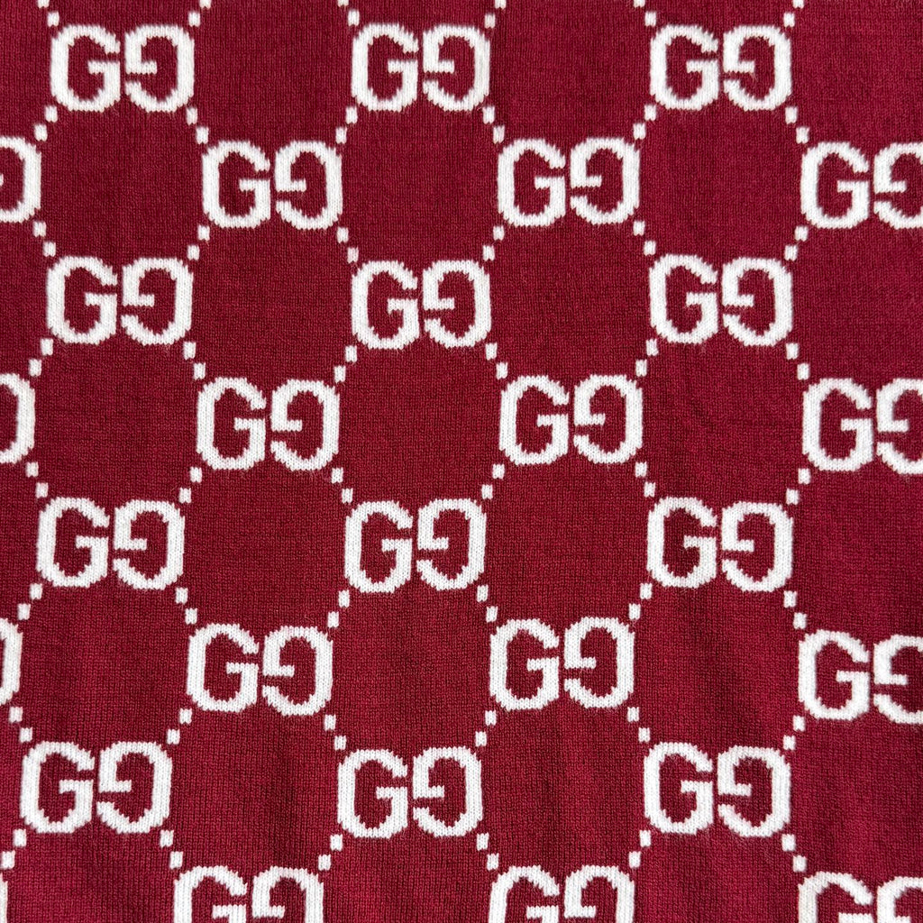 Close-up of burgundy Gucci knit fabric with white GG diamond logo pattern