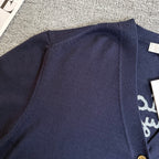 Navy Dior cardigan back yoke with ribbed trim, partial embroidered text visible