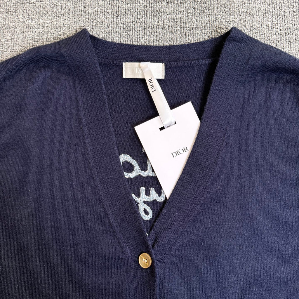 Navy Dior cardigan neckline with gold button and embroidered trim, brand tag at center