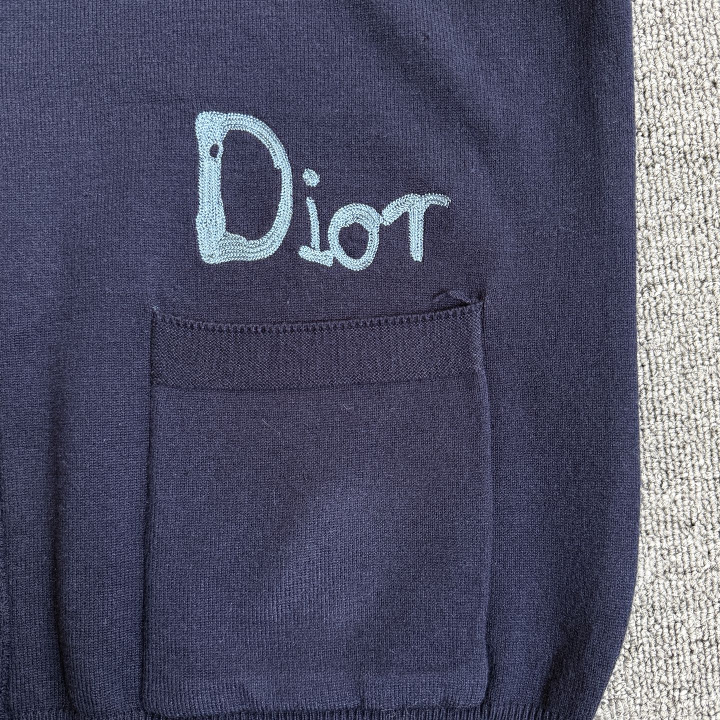 Navy Dior cardigan chest pocket with embroidered "Dior" logo on the left side
