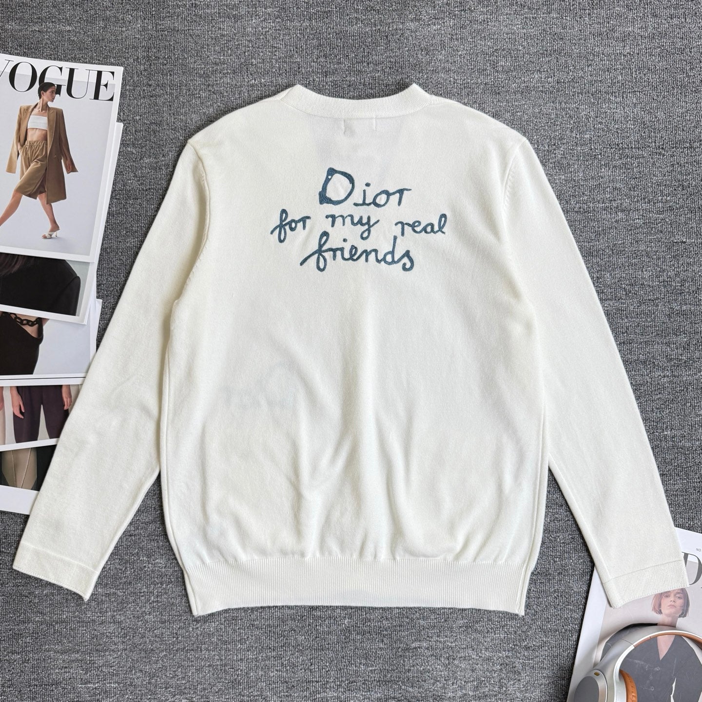 White long-sleeve cardigan sweater, back view with blue slogan embroidery