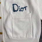 White cardigan sweater chest pocket with blue "Dior" embroidery