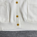 White cardigan sweater button placket with gold buttons and ribbed hem
