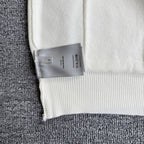 White knit cardigan sweater hem with brand size tag attached