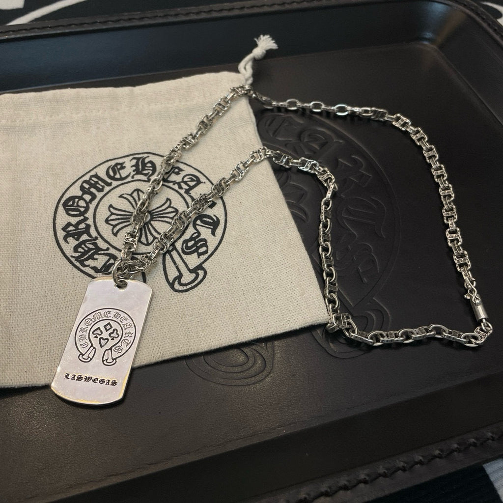 Silver-tone chain necklace with rectangular dog-tag pendant on pouch