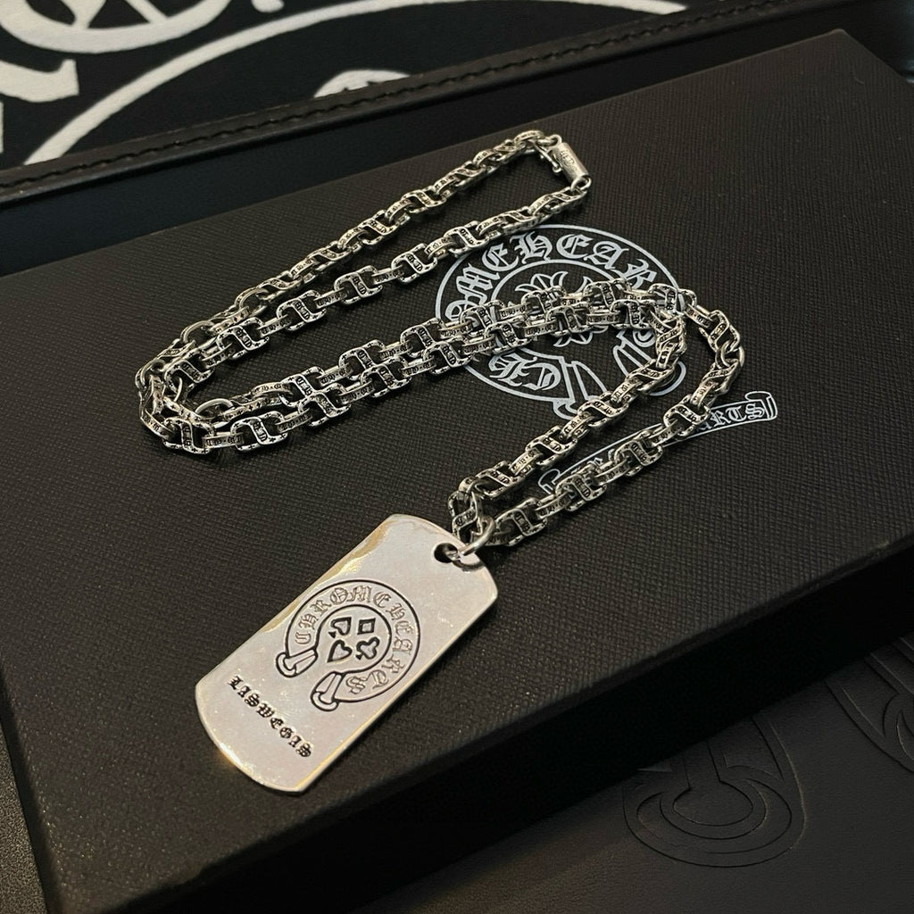 Silver-tone chain necklace with rectangular dog-tag pendant on black case