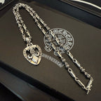 Heart and cross charm necklaces with silver-tone chains laid in jewelry box