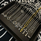Assorted silver-tone pendant necklaces with cross, anchor, and gold-tone accents