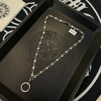 Silver-tone chain necklace with repeating coin charms and ring pendant