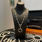 Silver-tone chain necklace with circular ring pendant and repeating coin charms