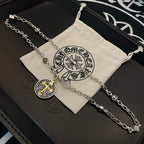 Silver-tone chain necklace with round gold-cross pendant on a beige fabric gift pouch