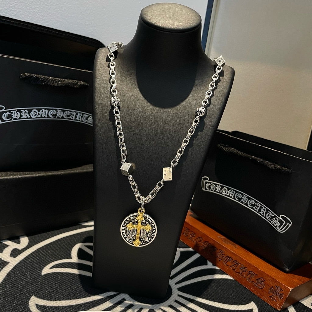 Silver-tone chain necklace with round gold-cross pendant displayed on a black necklace stand