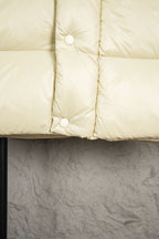 Long puffer jacket in light cream with quilted panels and snap buttons
