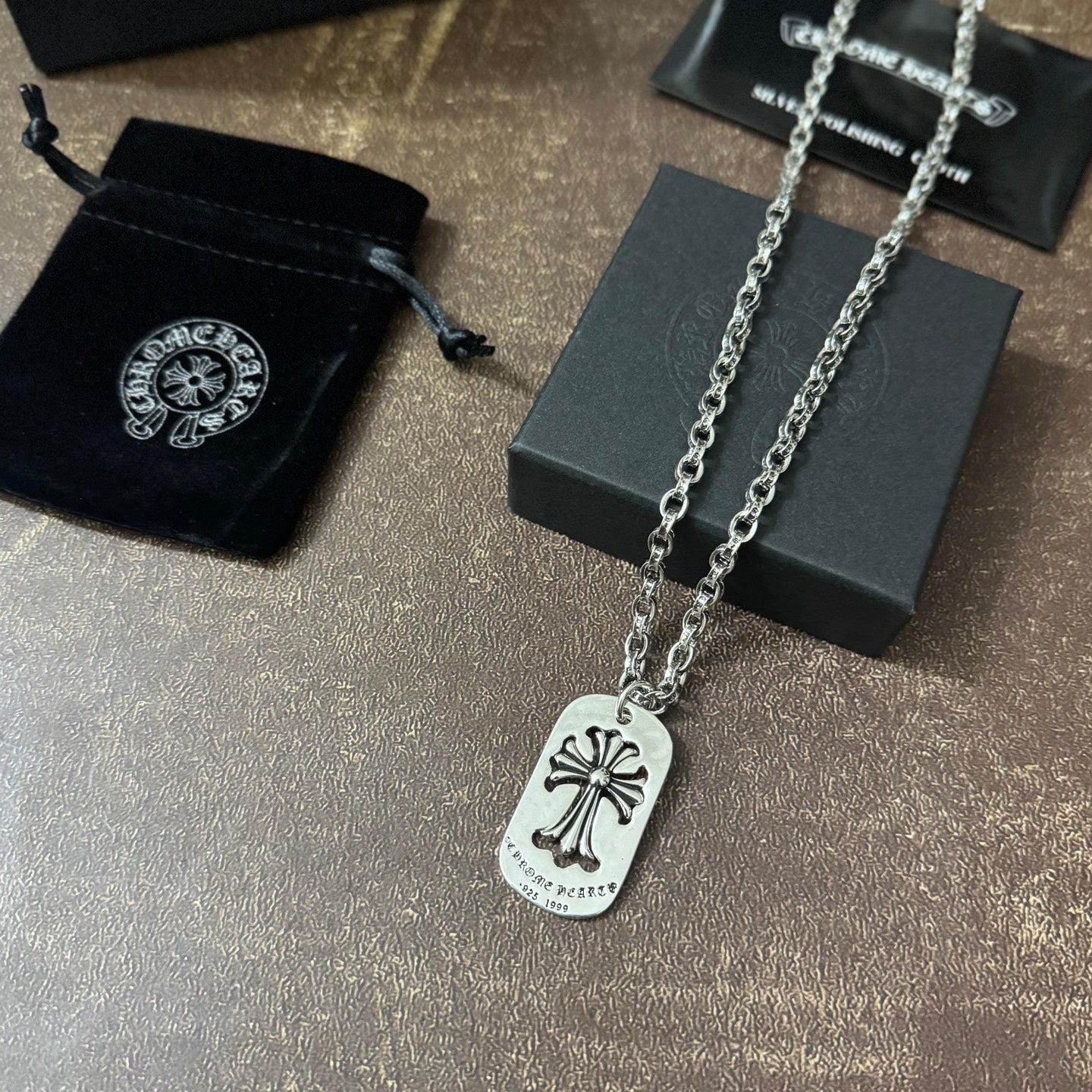 Chrome accessories necklace with silver dog-tag pendant and fleur-de-lis emblem