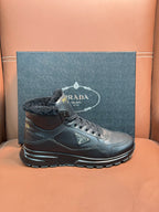 Prada lace-up boots with dark leather and faux-fur collar, side view on box