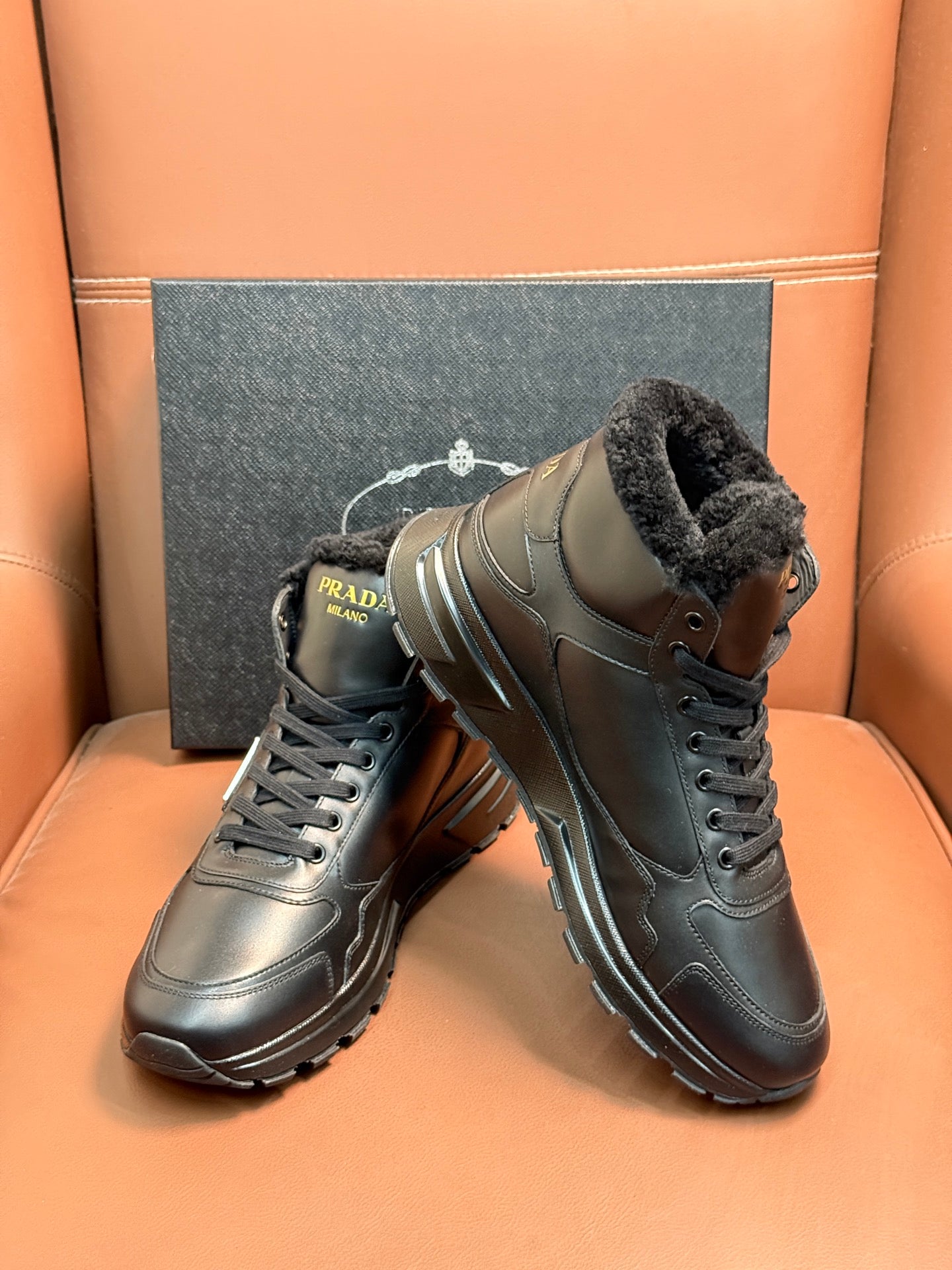 Prada lace-up boots with dark leather and faux-fur collar, front angle