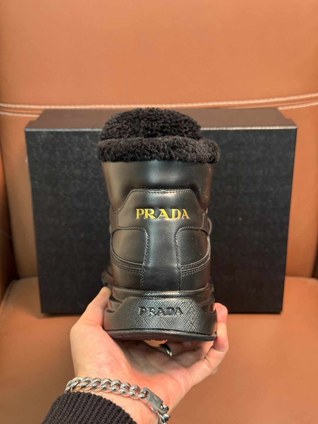 Prada boot heel view with dark leather and faux-fur collar, logo on back