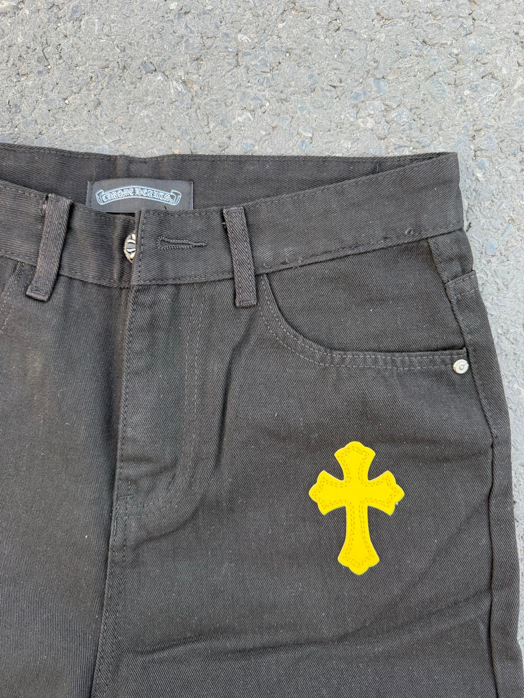 Chrome pants in gray fabric with yellow cross graphic on the front leg