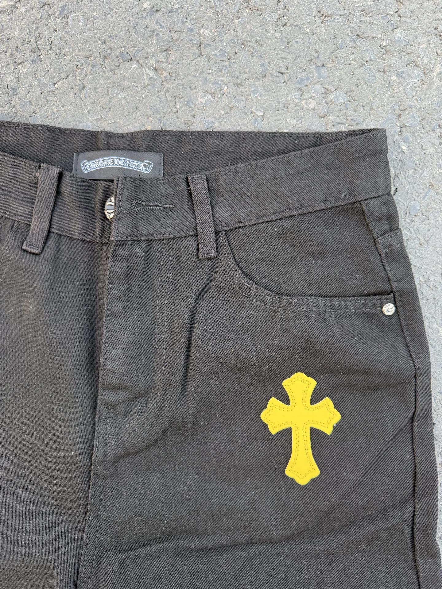 Chrome pants in gray fabric with yellow cross graphic on the front leg