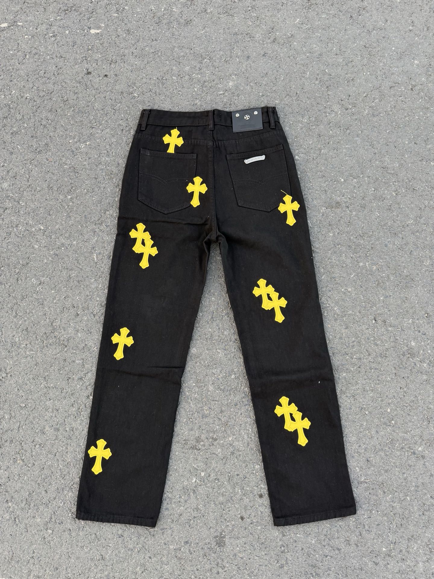 Chrome pants in dark fabric with yellow cross prints and front fly button closure