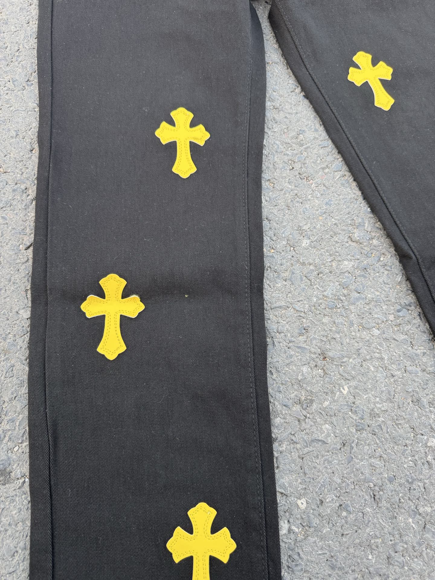 Black pants with yellow cross patches on the front leg