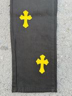 Black pants with yellow cross patches on the side hem area