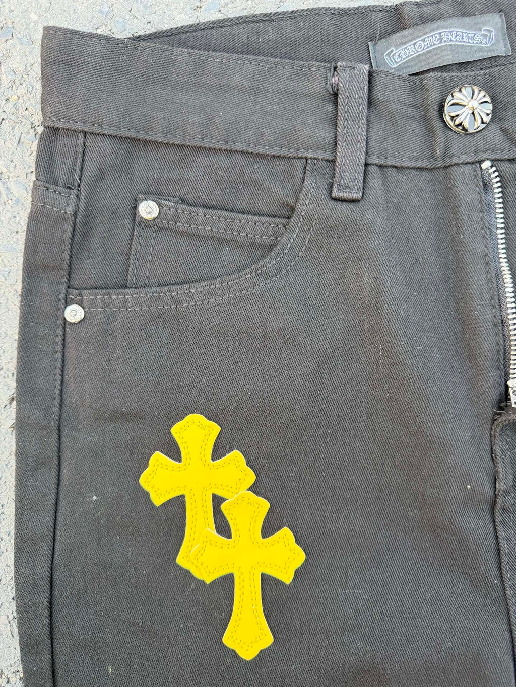 Chrome pants front pocket area in gray with a large yellow cross graphic