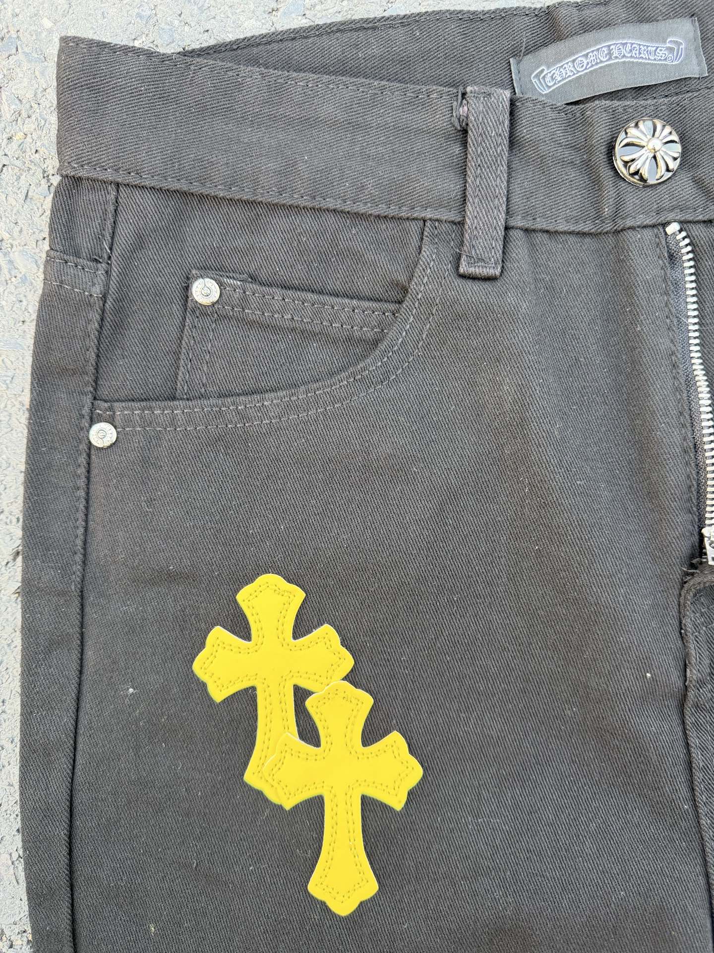 Chrome pants front pocket area in gray with a large yellow cross graphic