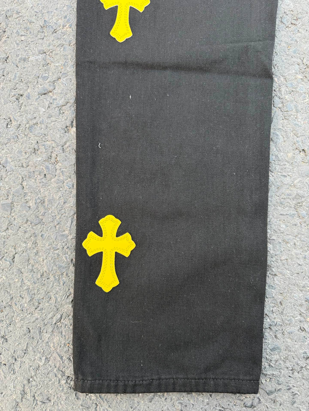 Black pants with yellow cross patches near the lower leg