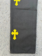 Black pants with yellow cross patches near the lower leg