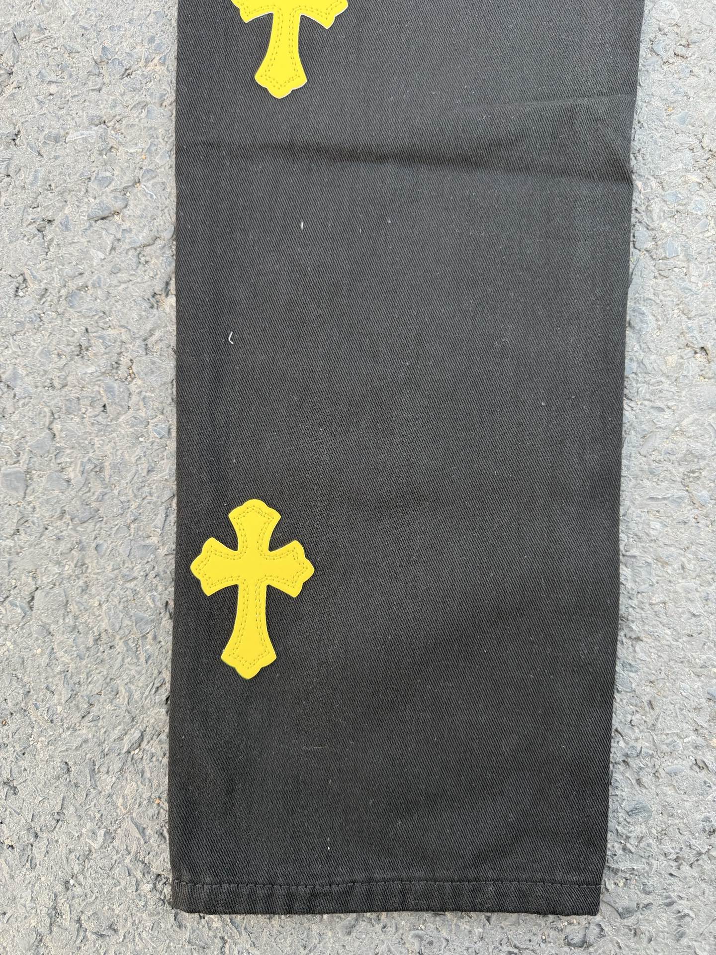 Black pants with yellow cross patches near the lower leg