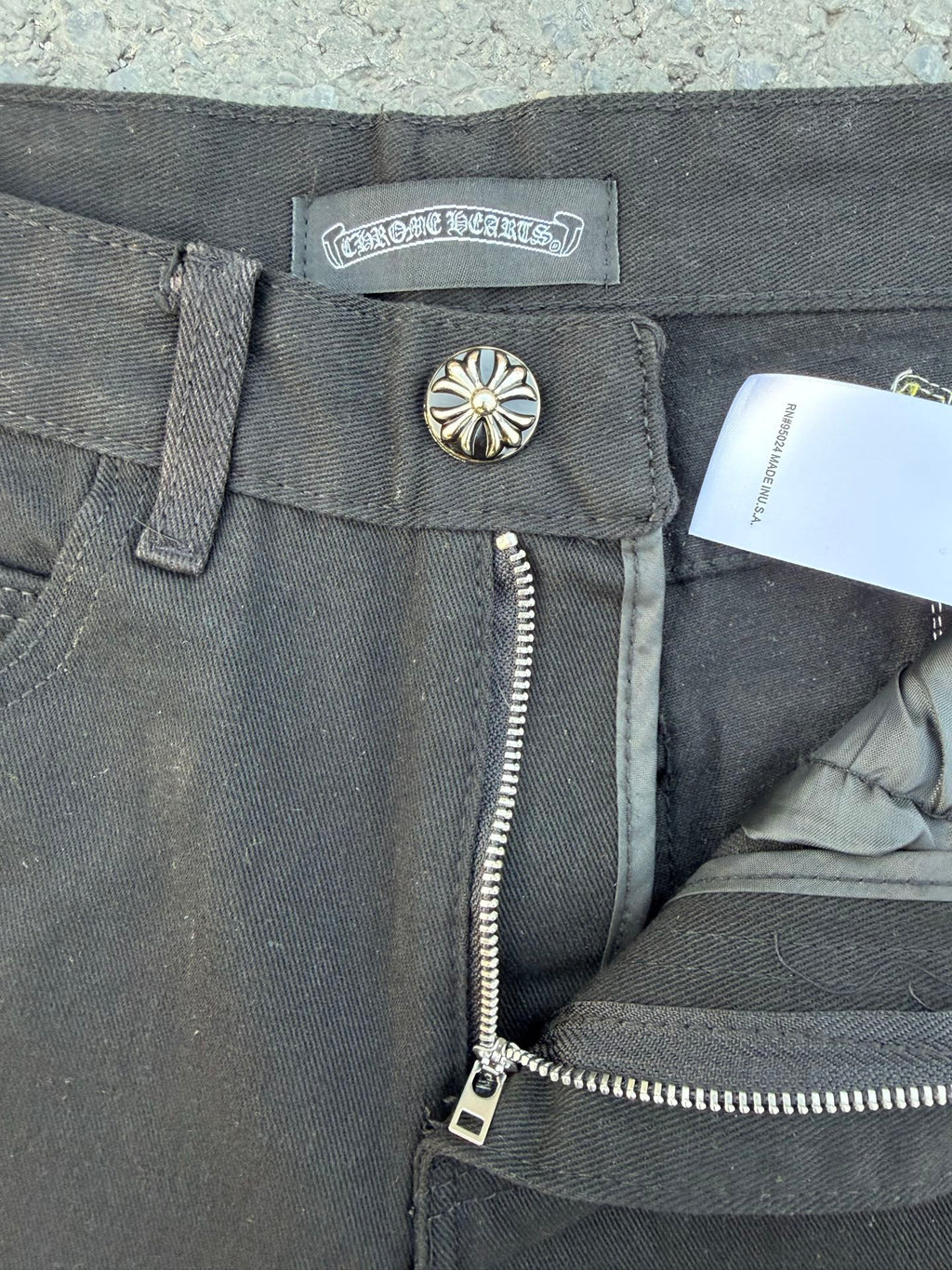 Chrome pants waistband and zipper fly in gray with a metal button and tag