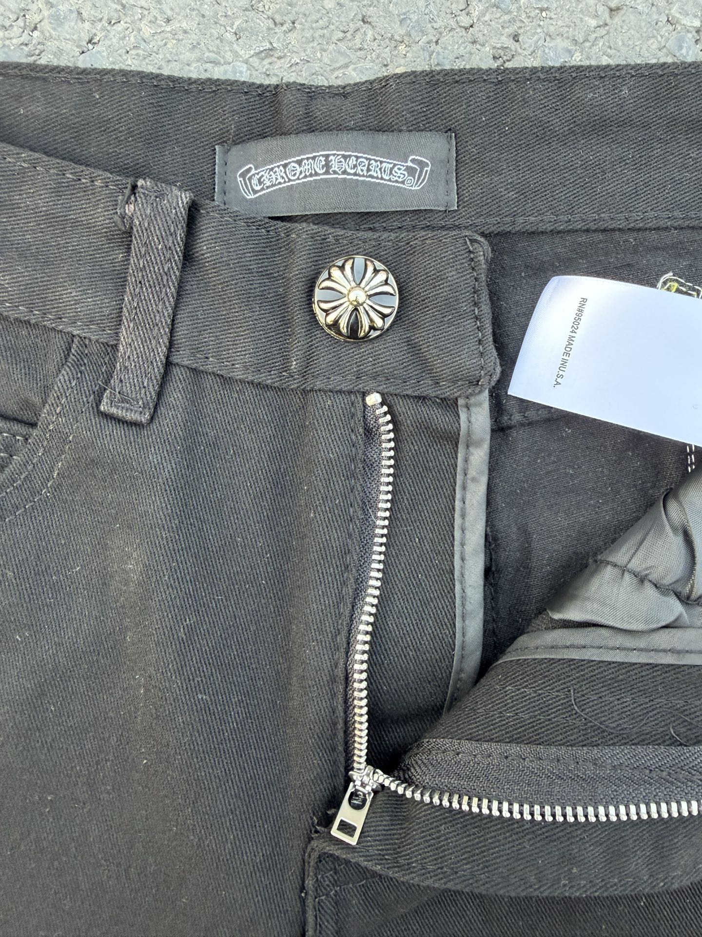 Chrome pants waistband and zipper fly in gray with a metal button and tag