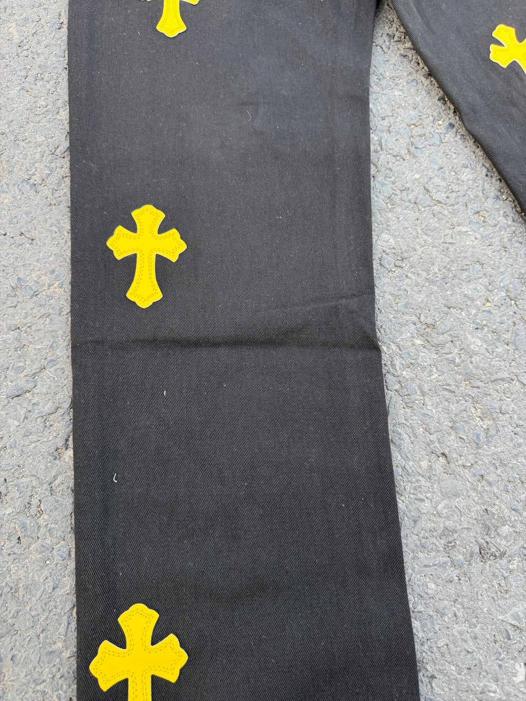 Black pants with yellow cross patches on the upper leg