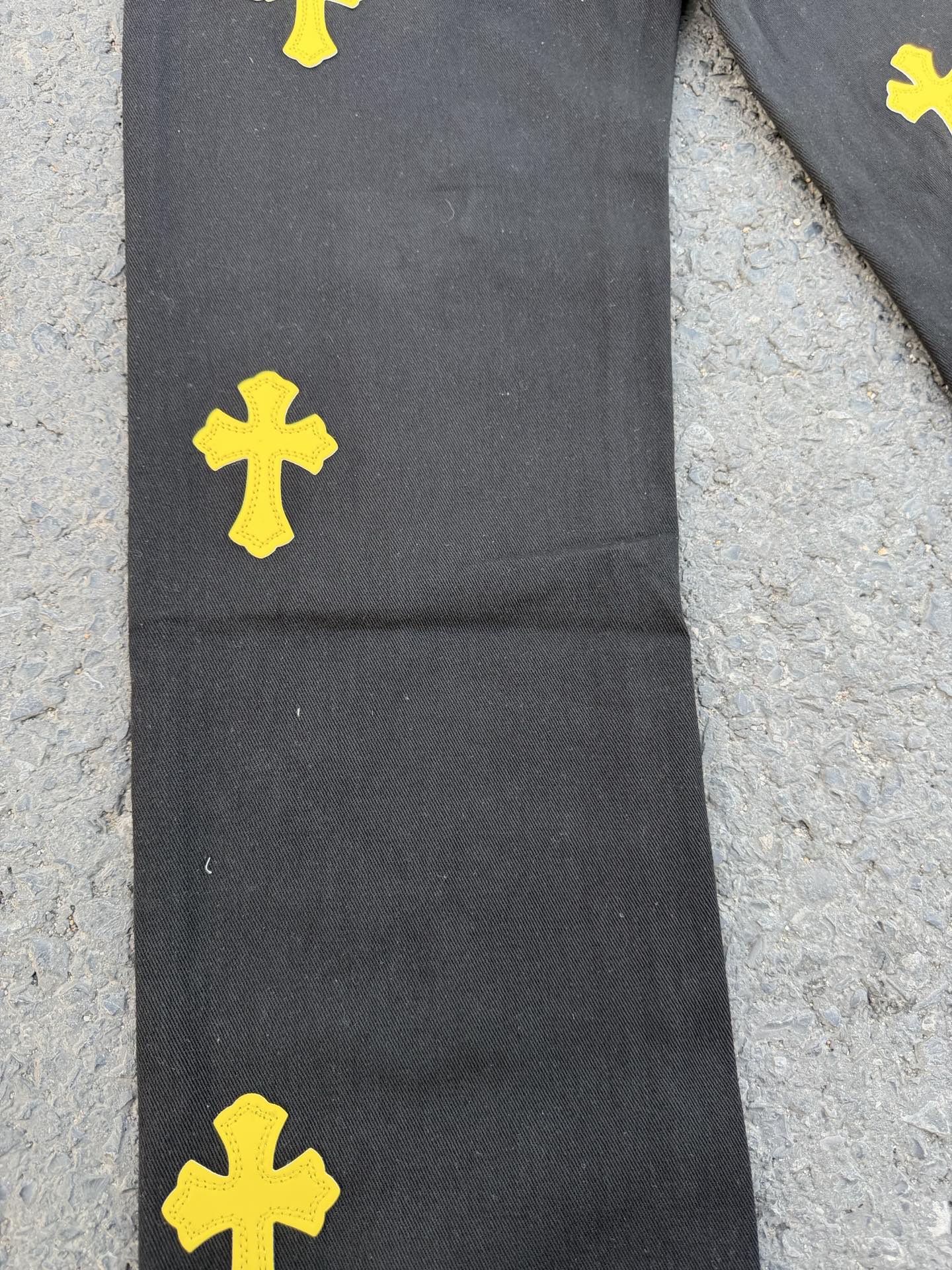 Black pants with yellow cross patches on the upper leg