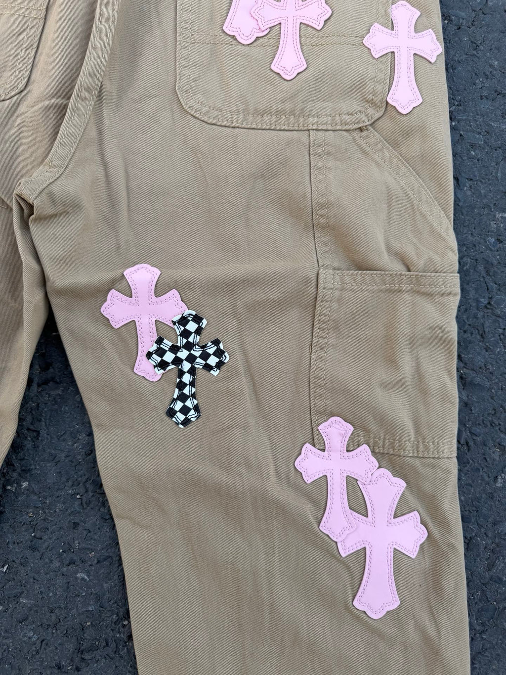 Beige pants close-up of side pocket with black-and-white cross patch