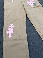 Beige pants front close-up with purple cross patches on leg pockets