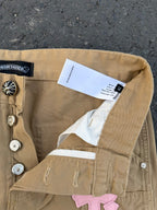 Beige pants close-up of back waistband and care label near snap buttons